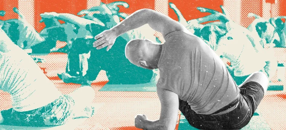 A man on a yoga mat stretching in a fitness class