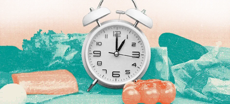 Alarm clock surrounded by fresh foods, representing intermittent fasting