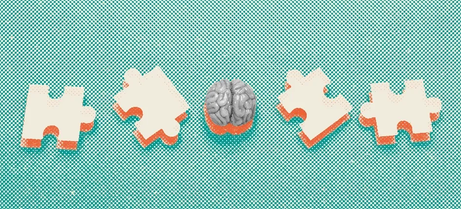 Small model of a brain surrounded by wooden puzzle pieces, symbolizing cognitive health and brain function.