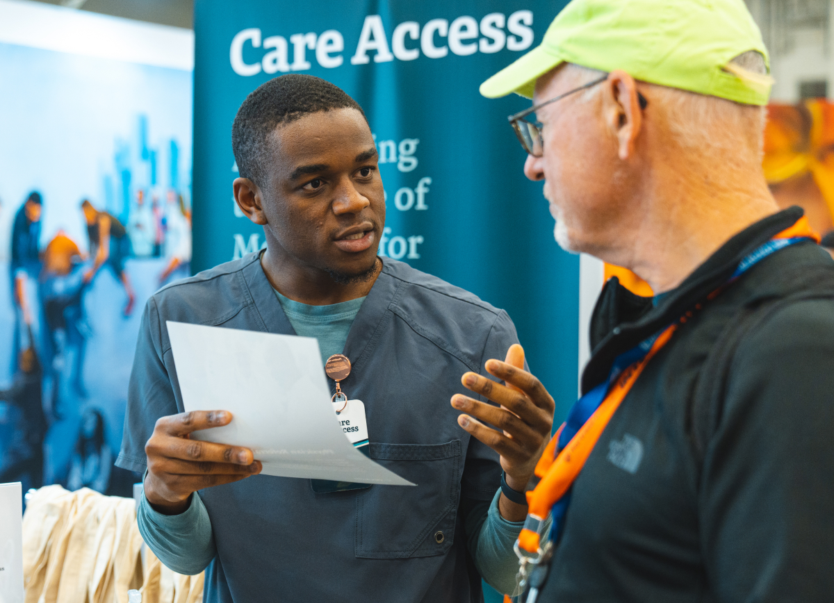 People talking at Care Access booth (SXSW 2023)
