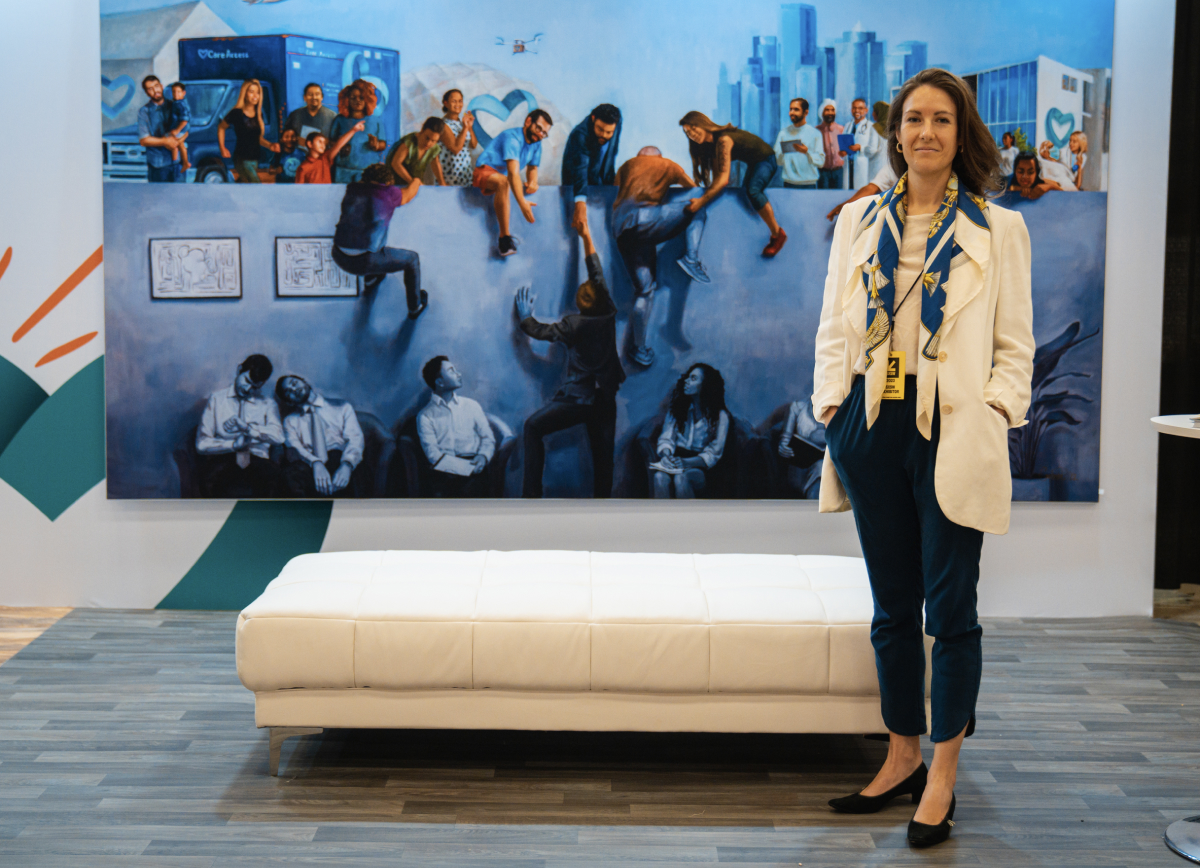 Artist Renée Caouette standing in front of her painting, "The Breakthrough" at SXSW 2023