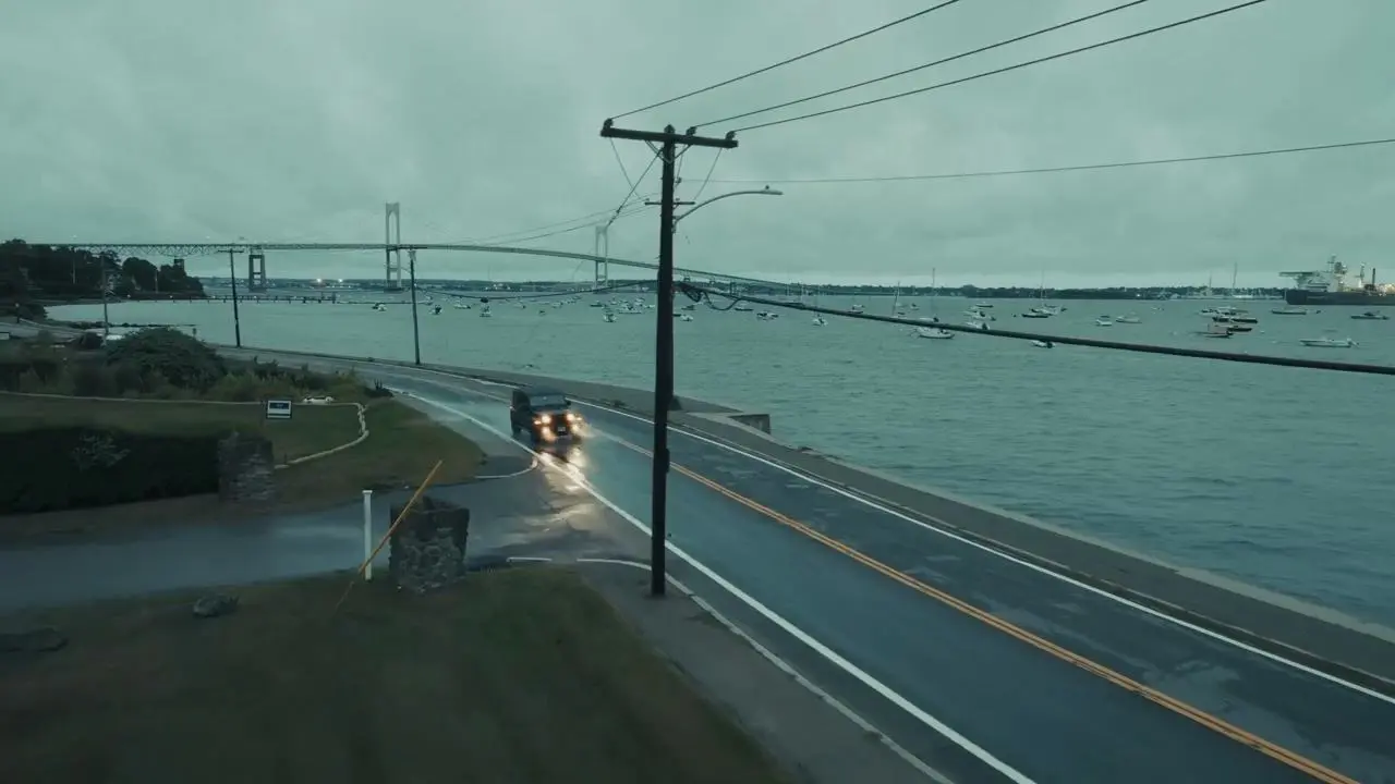 A car driving along a coastal road on an overcast day