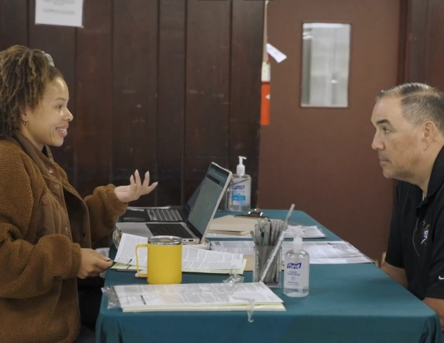 Woman speaking to man over paperwork