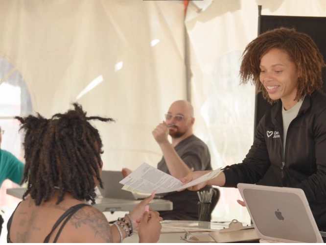 Smiling woman handing someone papers